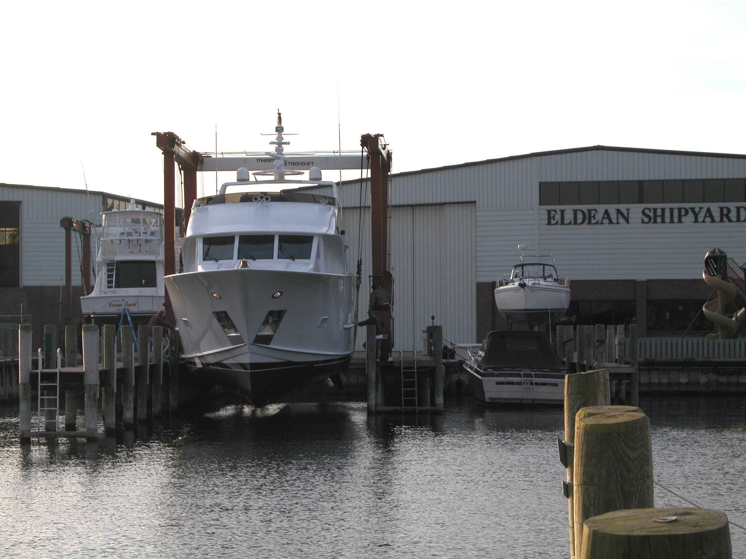 A motor yacht in the Eldean Shipyard travel lift beside the service buildings