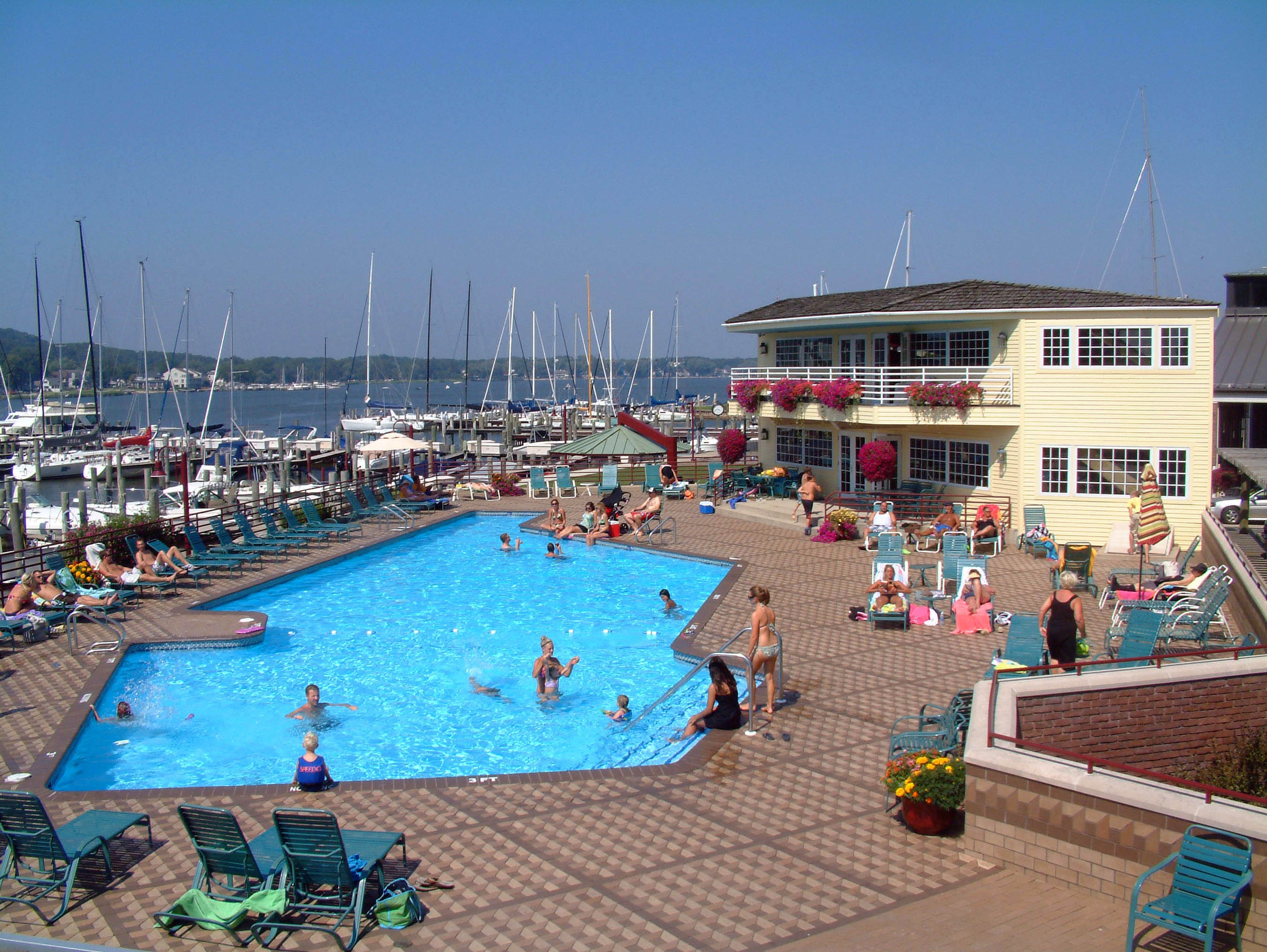 Boaters relaxing at the Eldean Shipyard swimming pool overlooking the marina